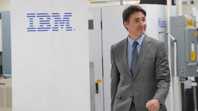 Justin Trudeau naglalakad habang dinaanan ang logo ng IBM sa tabi.