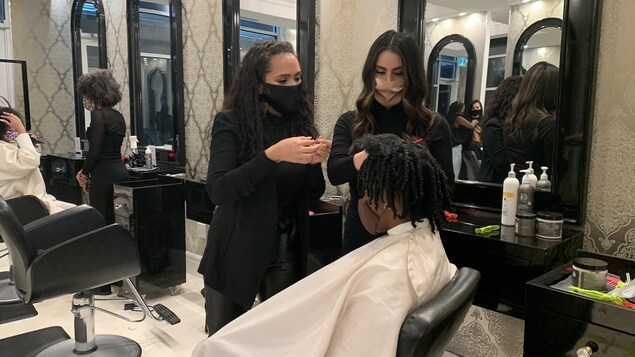 Des coiffeuses dans un salon de coiffure.