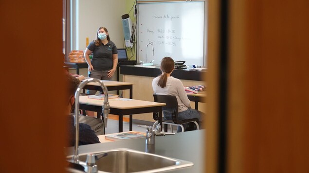 Une professeur enseigne en portant le masque.