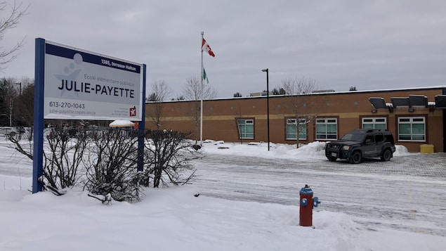 Façade de l'école entourée de neige avec l'affiche du nom de l'école primaire du Conseil des écoles publiques de l'Est de l'Ontario.