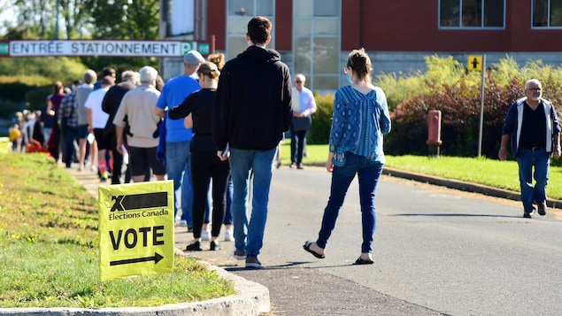 Des gens font la file pour aller voter.