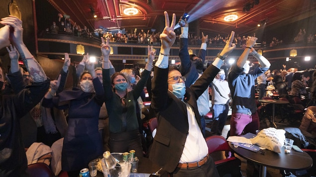 Des candidats, des militants et des membres de Projet Montréal les mains dans les airs.