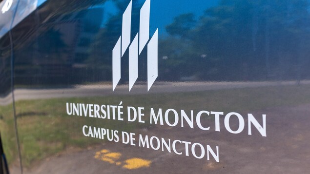 Le logo de l'Université de Moncton, campus de Moncton, imprimé sur le côté d'une voiture.