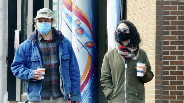 Deux personnes qui se promènent portant un masque au centre-ville de Moncton.