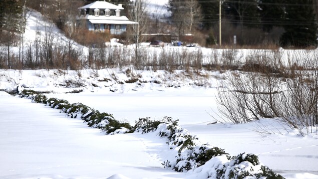 Une rivière sous la neige avec une estacade qui la traverse