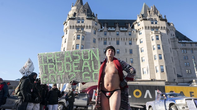 Un manifestante con ropa interior con una bandera canadiense.