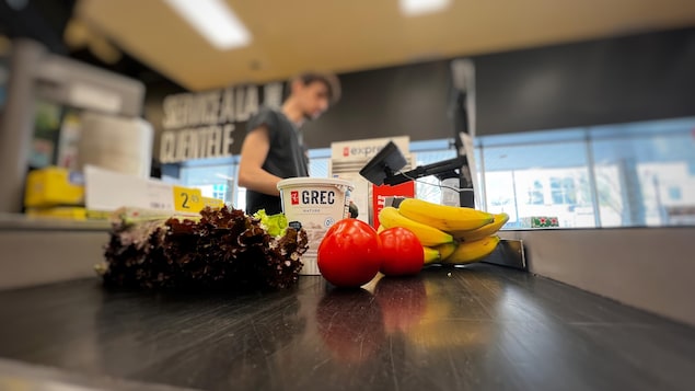 Des aliments sur le tapis roulant d'une caisse enregistreuse.