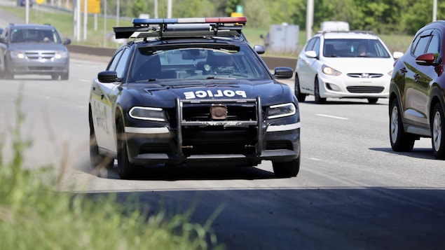 Une voiture de police circule sur l'autoroute.