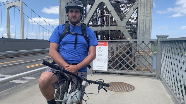 Le cycliste, Phillipe Michaud, sur son vélo, à l'entrée du pont de Québec.
