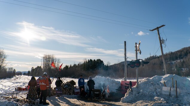 Une demi-douzaine de personnes discutent au campement des manifestants.