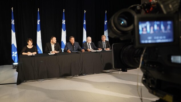 Des ministres québécois assis à une table lors d'une conférence de presse.
