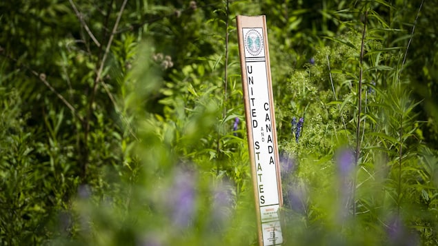 Un panneau vertical sur lequel on peut lire « United States and Canada », non loin du chemin Roxham.