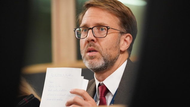 Le commissaire à la langue française du Québec, Benoît Dubreuil, tient une feuille dans ses mains.