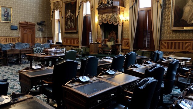 Les sièges des députés. La salle est déserte.