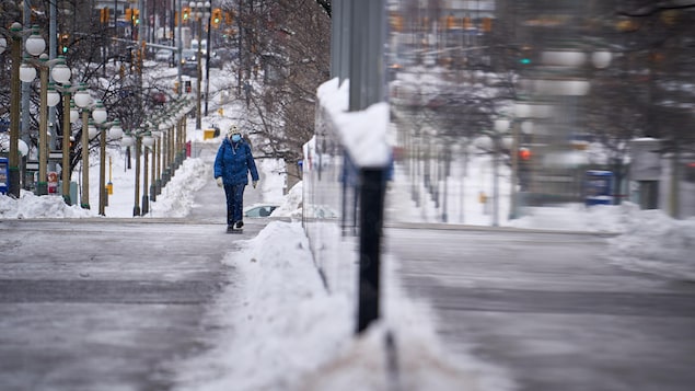 Un piéton sur un trottoir d'Ottawa l'hiver.