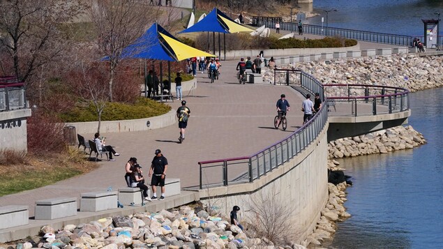Des piétons marchent sur la promenade River landing à Saskatoon par une belle journée de printemps.