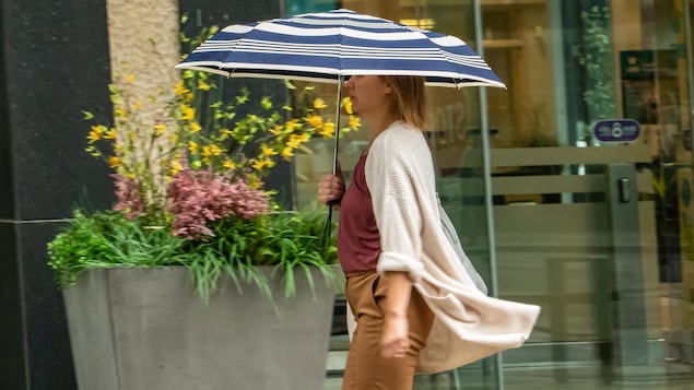 Une femme porte un parapluie lors d'une journée pluvieuse à Regina.