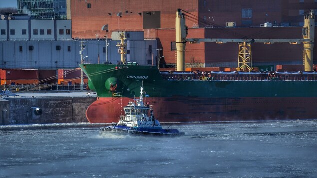 Un bateau navigue sur le fleuve près du port de Montréal.