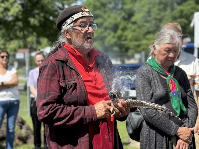 Un homme avec une plume et de la sauge et une femme à côté.