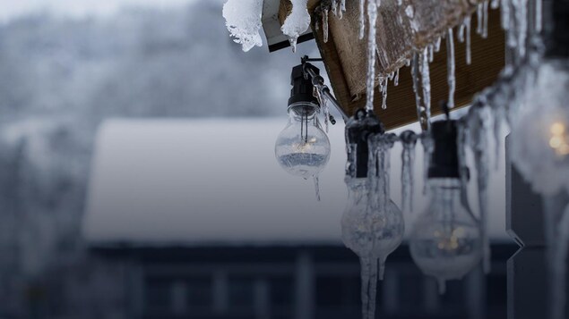 Des glaçons suspendus sur une maison démontrant le temps froid.