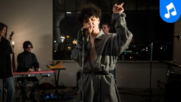 L'artiste offre une prestation avec ses musiciens.