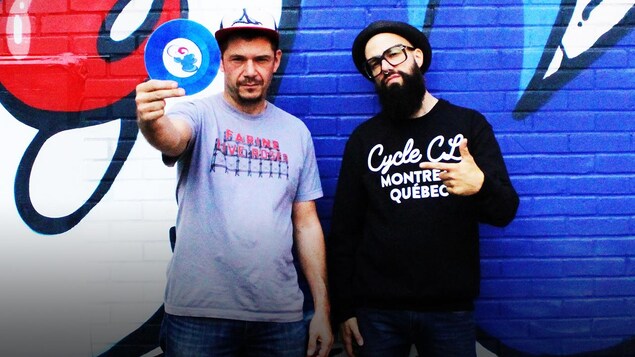 Horg et Seba se tiennent devant un mur couvert d'un graffiti. Horg et Seba se tiennent devant un mur couvert d'un graffiti.