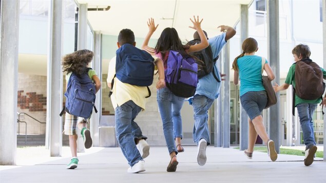 Une groupe d'enfants sort de l'école.
