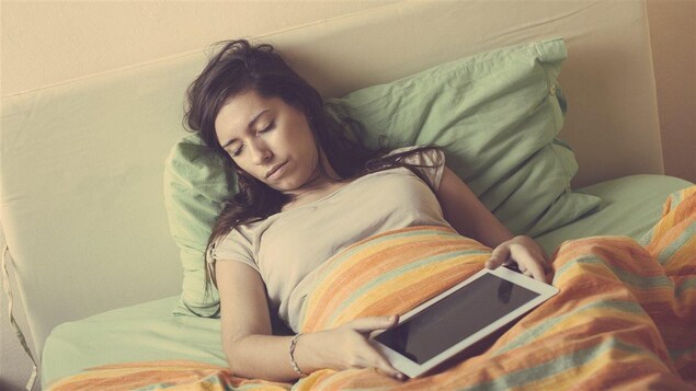 Une femme en train de dormir au lit.