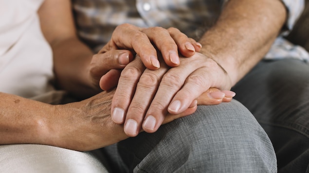 Les mains d'une femme tiennent les mains d'un homme.