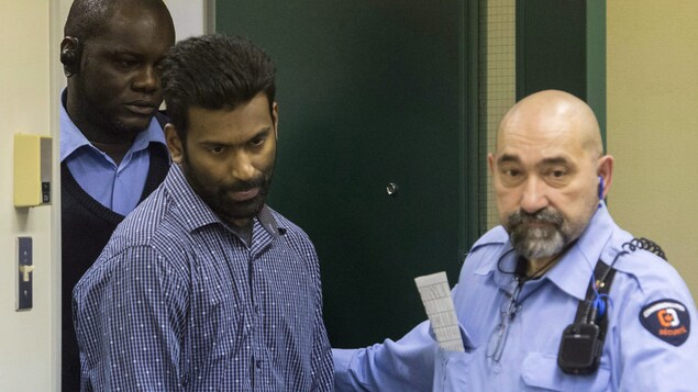 Sivaloganathan Thanabalasingham, entouré de deux gardes de sécurité, arrive à la Commission de l'immigration et du statut de réfugié du Canada à Montréal le jeudi 13 avril 2017. Sivaloganathan Thanabalasingham, entouré de deux gardes de sécurité, arrive à la Commission de l'immigration et du statut de réfugié du Canada à Montréal le jeudi 13 avril 2017.