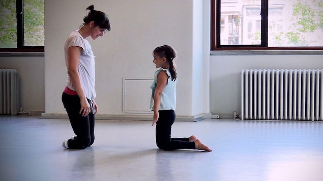 Une mère et sa fille dansent ensemble. La mère a les deux jambes amputées.