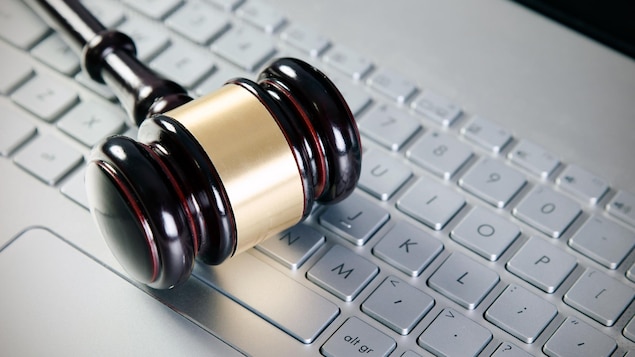 Un maillet de juge sur un clavier d'ordinateur.