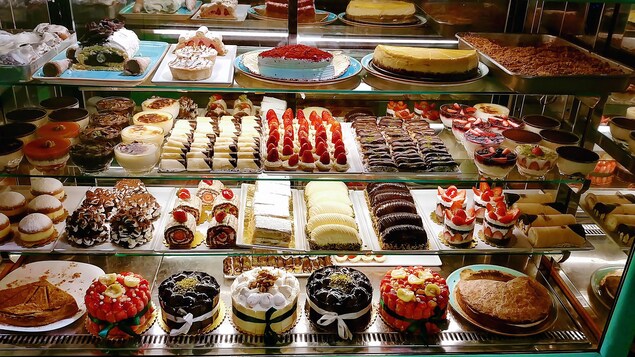 Différents desserts sont disposés dans un présentoir.