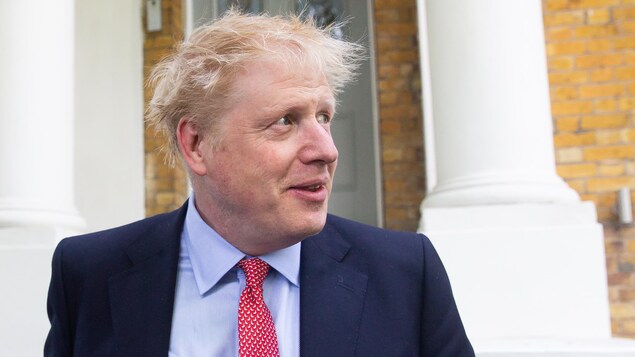 Boris Johnson regarde à sa gauche en sortant de chez lui, à Londres.