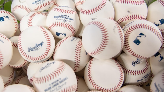 Des dizaines de balles de baseball dans un panier.