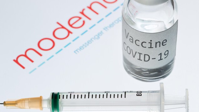 Une seringue et un flacon portant l'inscription « Vaccine COVID-19 » à côté du logo de la société de biotechnologie Moderna.