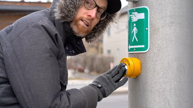 Marc-André Carignan pointe un bouton pour piéton.