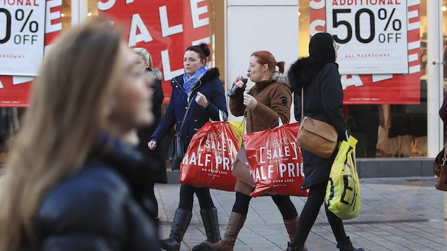 Des consommateurs déambulent dans les rues de Liverpool, en Angleterre. 