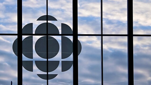 Une fenêtre qui laisse entrevoir un ciel nuageux et le logo de Radio-Canada.