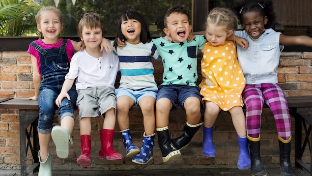 Six enfants sont assis sur un banc.