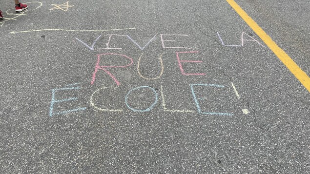 Vive la rue école écrit sur le pavé à l'aide de craie de plusieurs couleurs