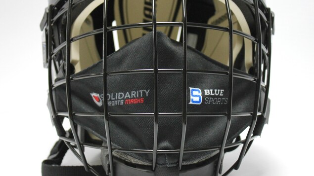 Un casque de hockey auquel est accroché un masque.