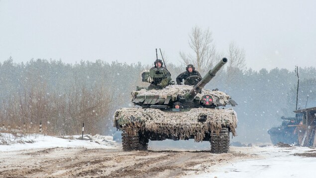 Un char militaire transportant trois soldats 