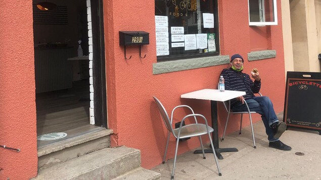 Jean-Pierre Centeno est assis à l'extérieur, devant son restaurant aux murs ocres.
