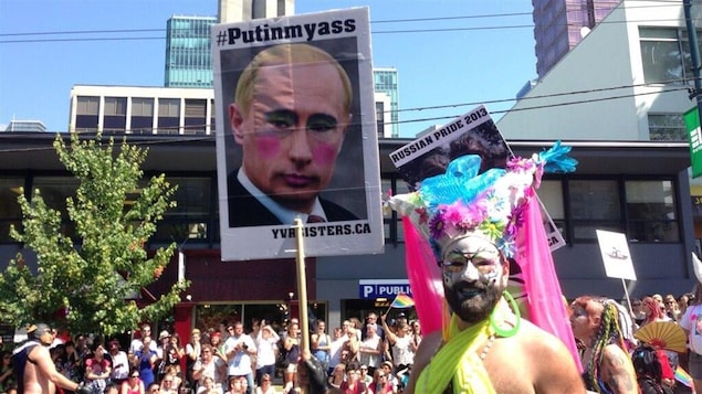 Un participant au défilé de la fierté gaie de Vancouver brandit une pancarte affichant une caricature du président russe, le 4 août 2013.