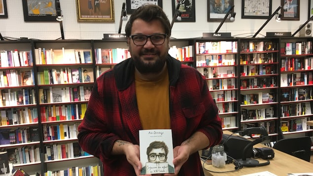 Un homme tenant un livre dans une librairie