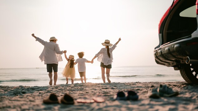 Une famille de vacanciers se trouve sur une plage.