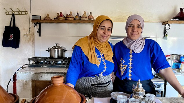 Deux femmes devant un plateau, prêtes à servir le thé. 