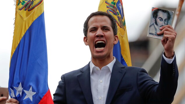 Juan Guaido, qui s'est proclamé président par intérim du Venezuela, tient un exemplaire de la constitution du pays lors d'un rassemblement contre le gouvernement de Nicolas Maduro, à Caracas, le 23 janvier 2019.