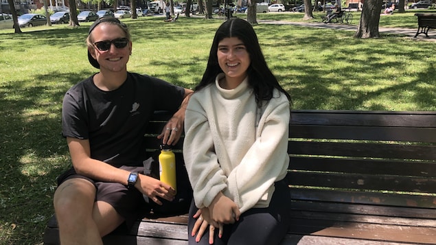 Un jeune homme et une jeune femme assis sur un banc de parc